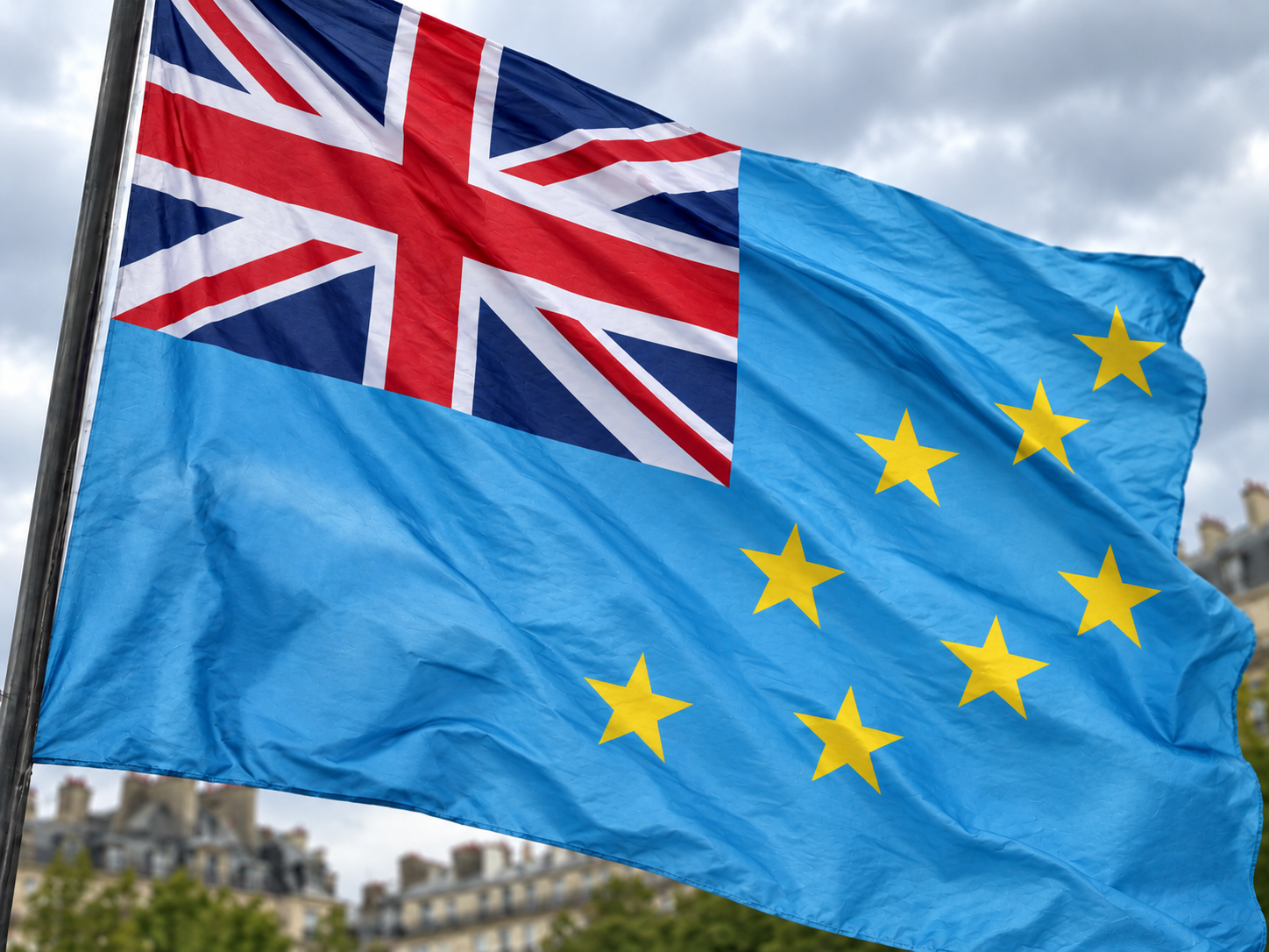 The national flag of Tuvalu, with a light blue field, Union Jack, and yellow stars